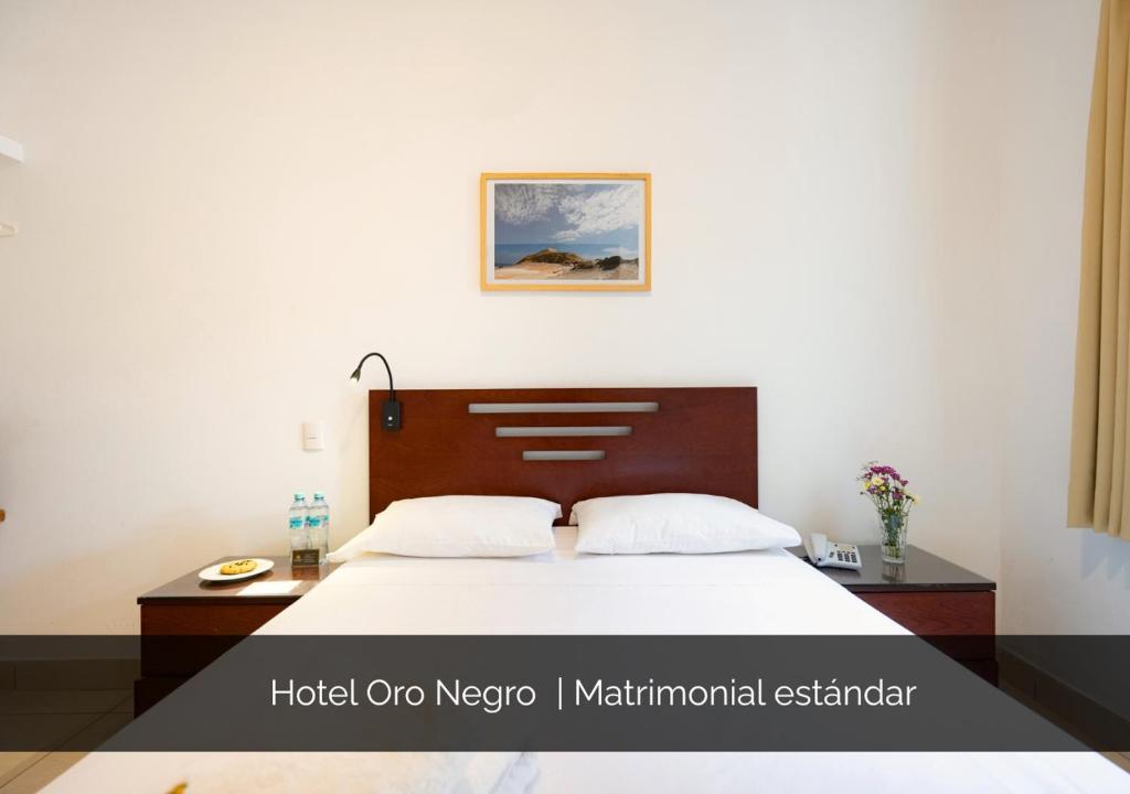 a bedroom with a bed with a wooden headboard at Hotel Oro Negro in Talara