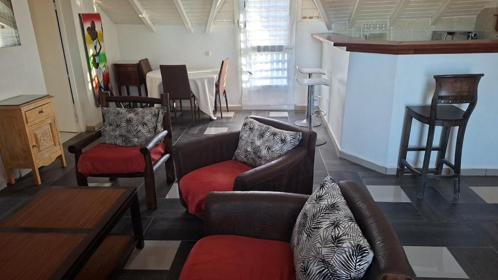 a living room with couches and chairs and a bar at Spacious 2 beds flat in Grande-Terre center in Morne-à-lʼEau