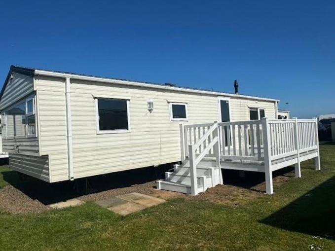 a white mobile home with a porch and stairs at Eyemouth caravan for rent in Eyemouth