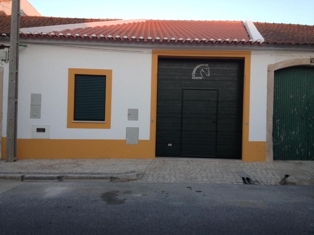 a black garage door with a horse drawn on it at Condomínio Equestre in Golegã