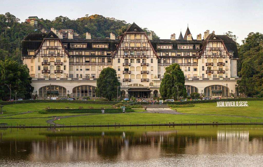 a large building with a lake in front of it at Loft no Hotel Quitandinha Experiência Única in Petrópolis