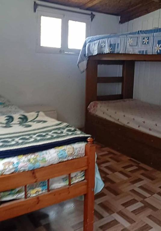 a bedroom with two bunk beds and a window at Departamento interior centro de el tabo in El Tabo