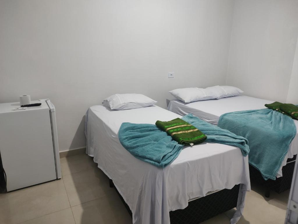 two beds with towels on them in a room at Hotel Stones in Jaraguá