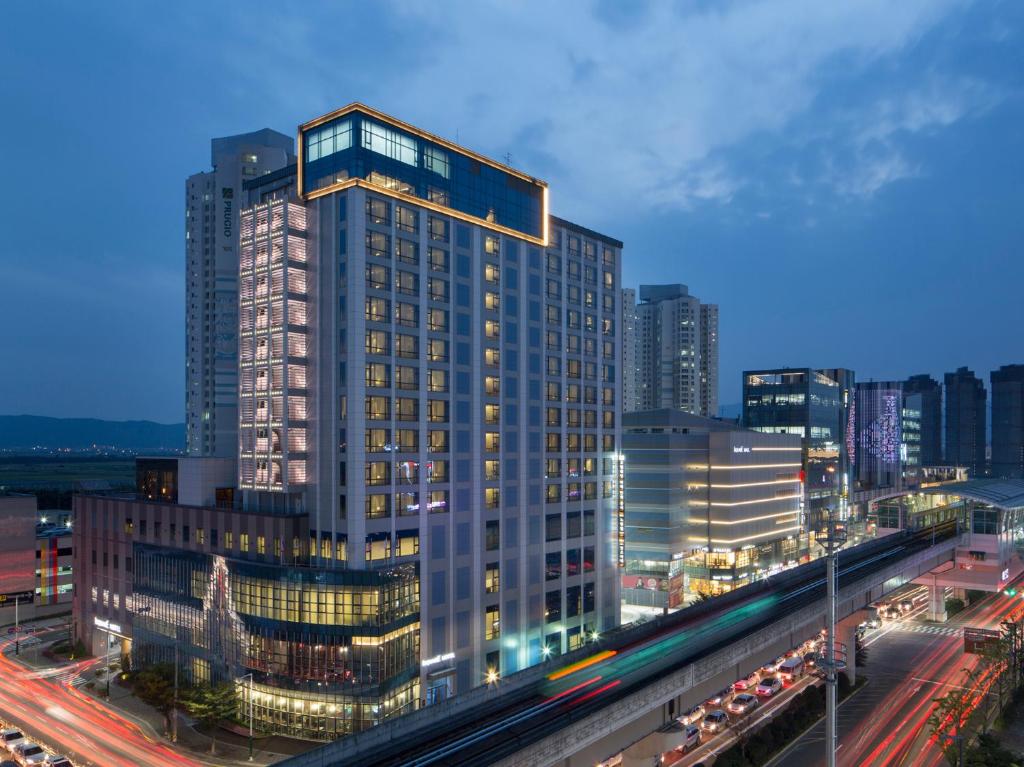 a tall building in a city at night at I Square Hotel in Gimhae