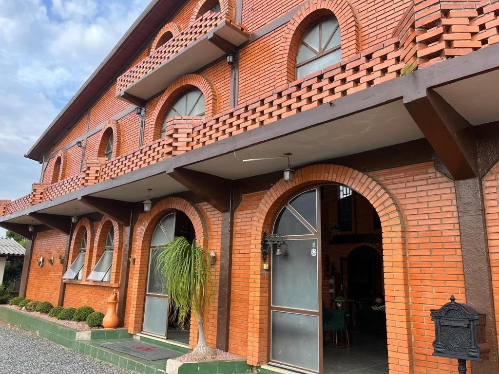ein rotes Backsteingebäude mit einem Bogeneingang in der Unterkunft Hotel Blumenpark in Rio Negro