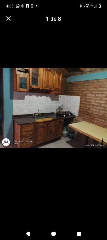 a kitchen with wooden cabinets and a wooden table at Elu in Ingeniero Giagnoni