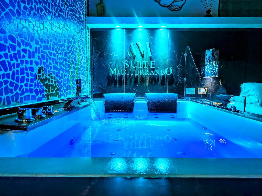 a bath tub with blue lights in a bathroom at Suite Mediterraneo in Civitavecchia