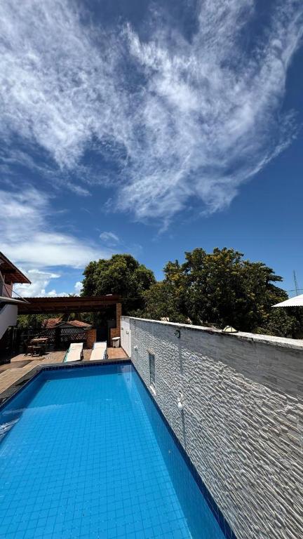 a swimming pool with blue tiles on a wall at Pousada Manancial in Itaúnas