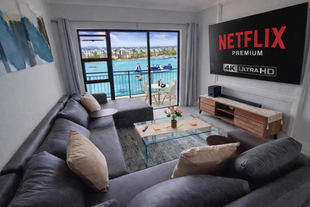a living room with a couch and a large window at Spectacular Lagoon Facing Apartment - The Blyde in Pretoria