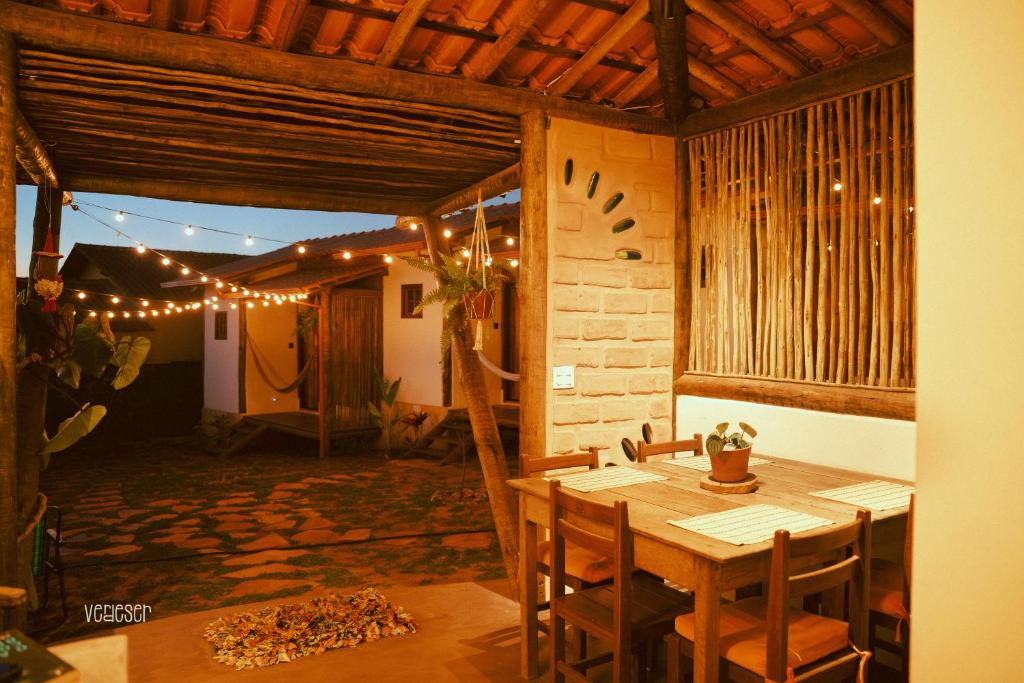 a dining room with a wooden table and lights at Chalés VerdeSer in Sêrro