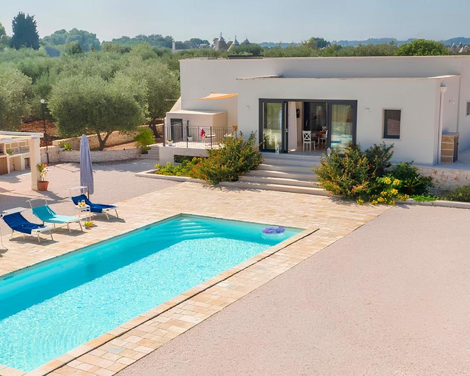 a villa with a swimming pool in front of a house at Stefano's Villa in Cisternino