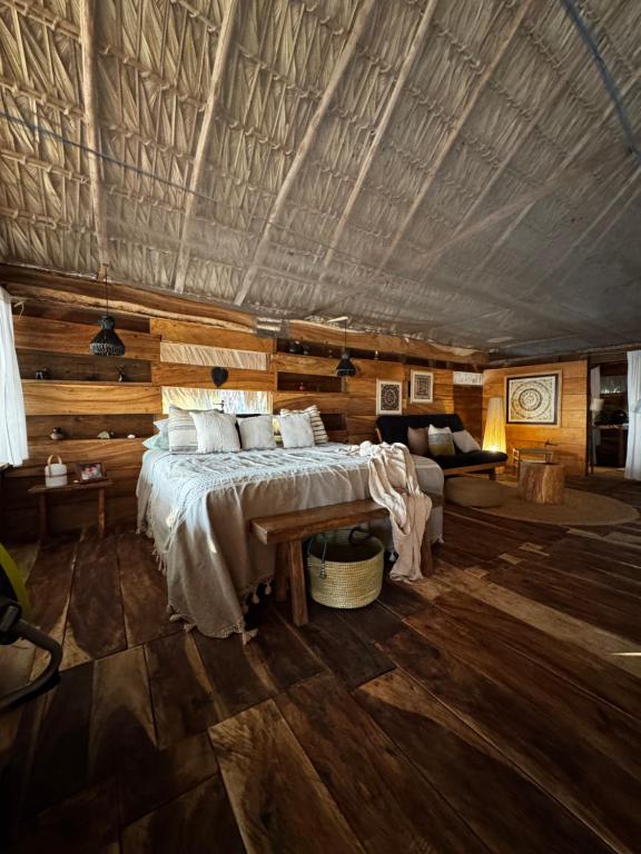 una camera da letto con un letto in una stanza con pareti in legno di Cabañas Casa de Agua a Boca del cielo