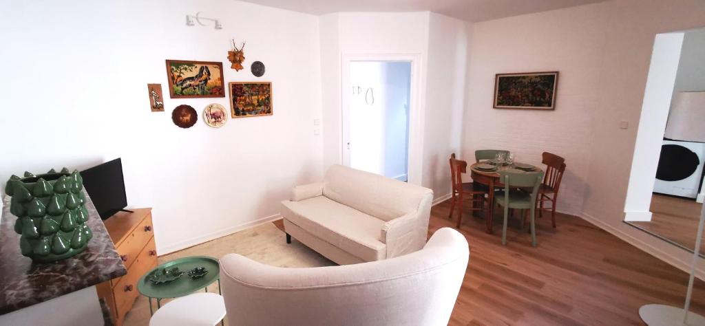 a living room with a couch and a chair and a table at La Maison Trente in Chooz