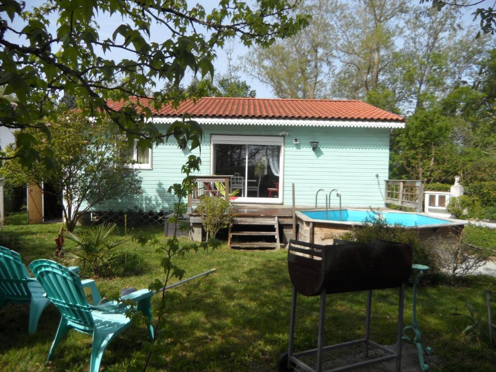 a small blue house with a pool in the yard at Maison dans un écrin de verdure in Sorèze