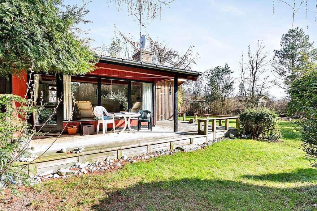 a house with a deck with a table and chairs at 3000-Stege-Stejlepladsen-13 in Stege