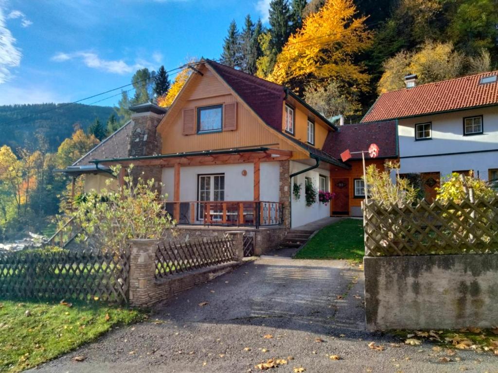 a house in the mountains with a fence at Ferienhaus Bauer Wohnung 2 in Trattenbach