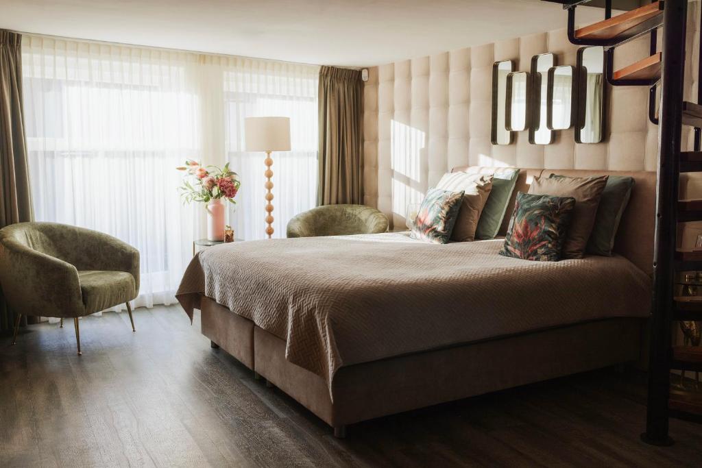 a bedroom with a bed and a chair and a window at City Attic Haarlem in Haarlem