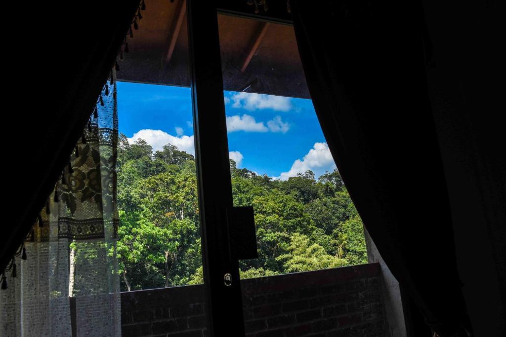a window with a view of trees and a blue sky at Shrine Inn in Kandy
