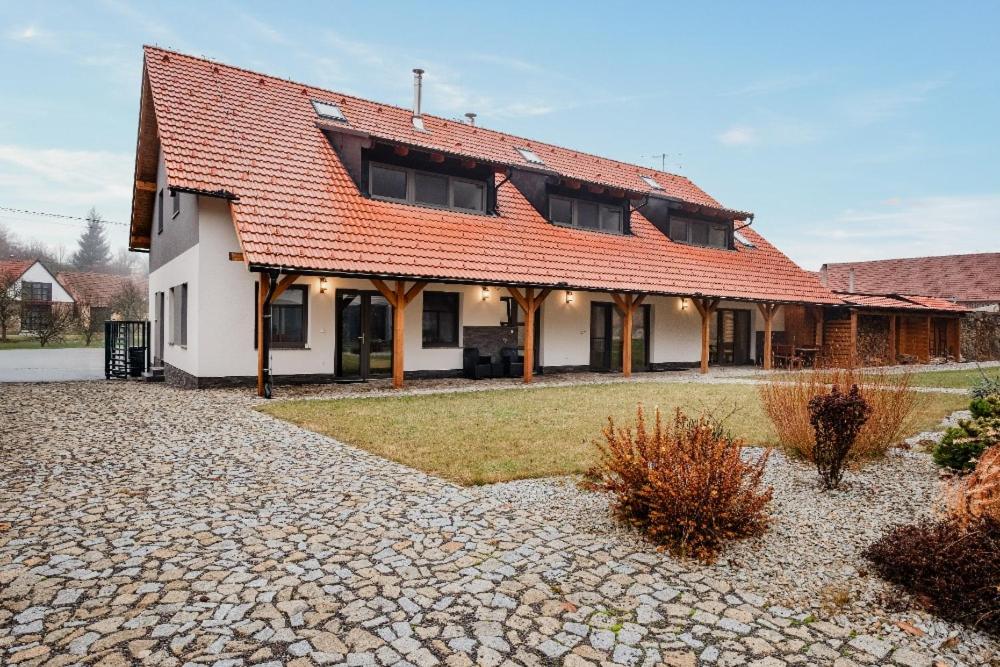 a house with a red roof on a stone driveway at Chalupa u Rašovských in Jasenice