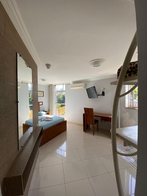 a bedroom with a bed and a desk in it at Garden Hotel in Nova Era