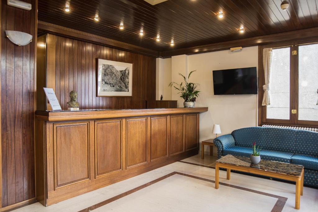 a waiting room with a blue couch and a tv at Hotel Villa Apollonia Delphi in Delphi