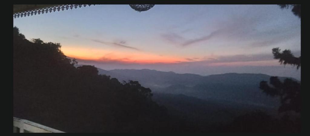 a view of a mountain with a sunset in the background at Agape center in Haputale