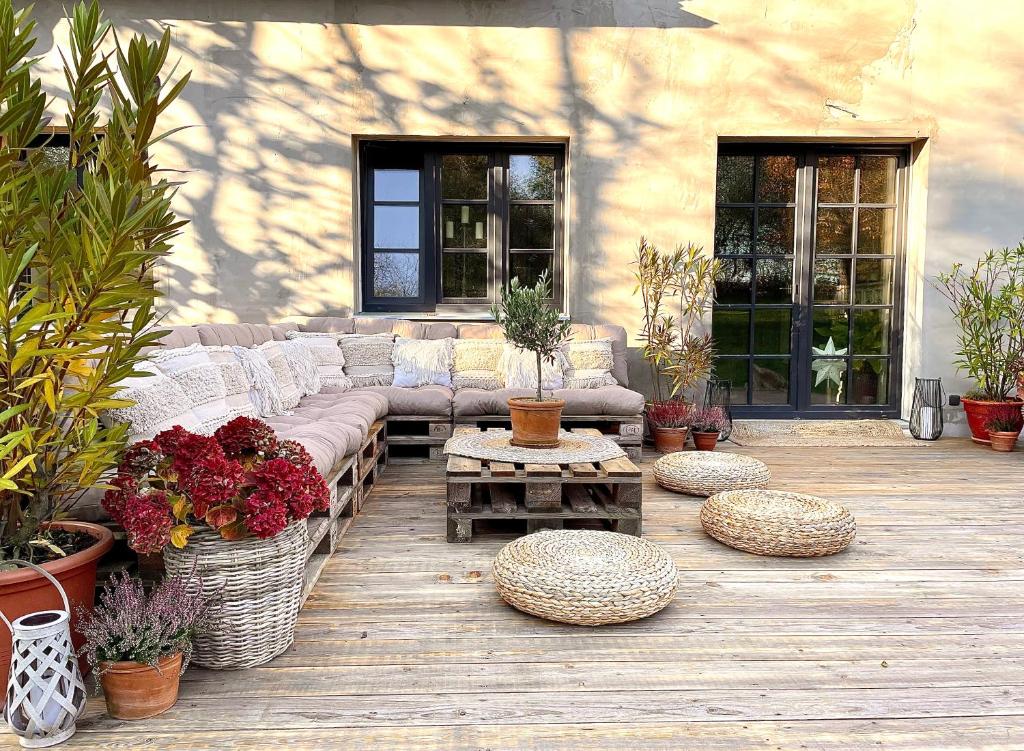 a patio with a couch and tables and plants at Honey Gardens venkovský apartmán v přírodní zahradě in Oleška