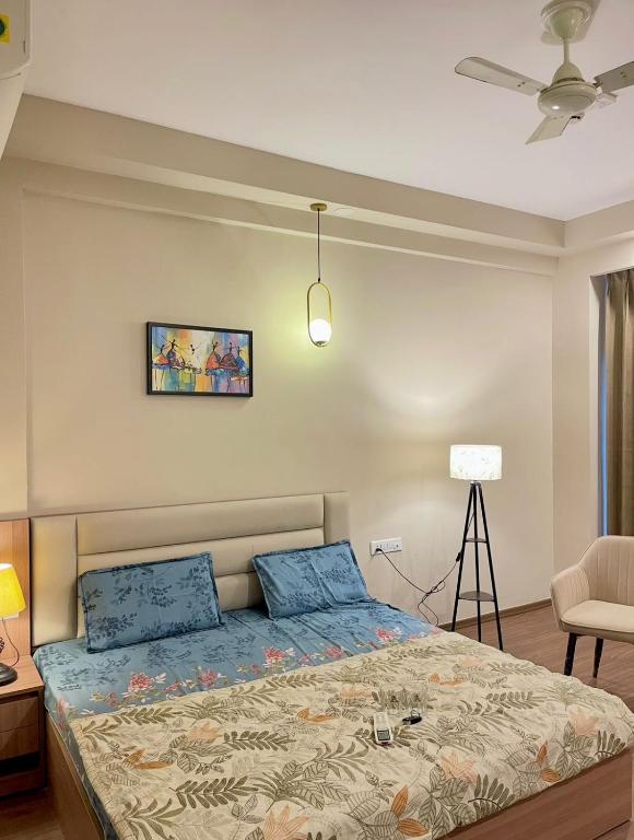 a bedroom with a bed with blue pillows at The Sterling Omaxe Near Expo Mart in Greater Noida
