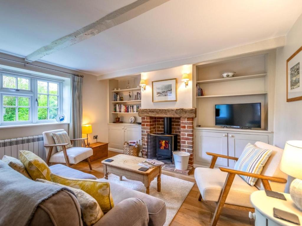 a living room with a fireplace and a tv at 2 Bed in Kelling Holt oc-76755 in Kelling