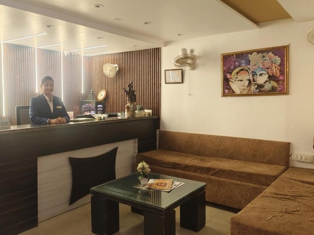 a woman standing at a bar in a living room at Hotel Ravi Palace Agra in Agra