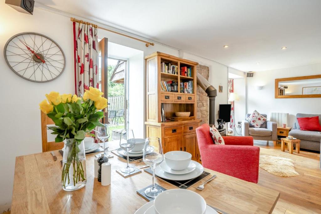 a living room with a table with a vase of flowers at 2 Bed in Govilon oc-u32754 in Govilon