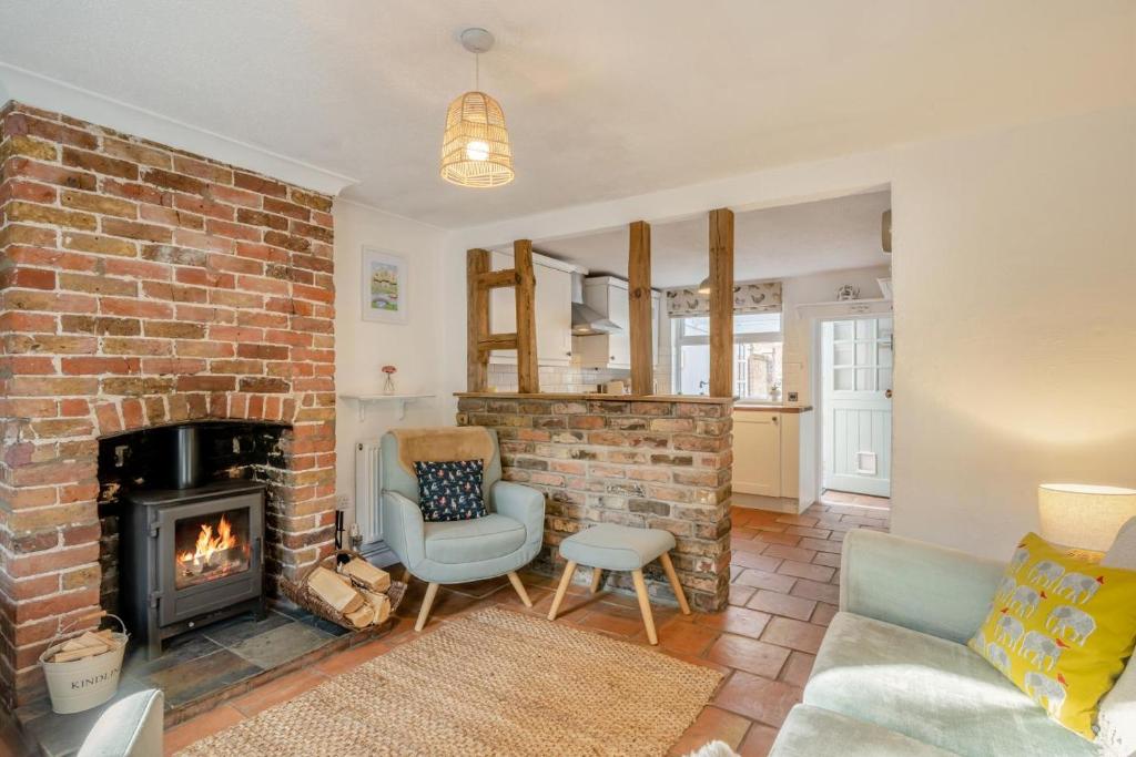 a living room with a brick fireplace and a chair at 2 Bed in Beccles oc-d33611 in Beccles