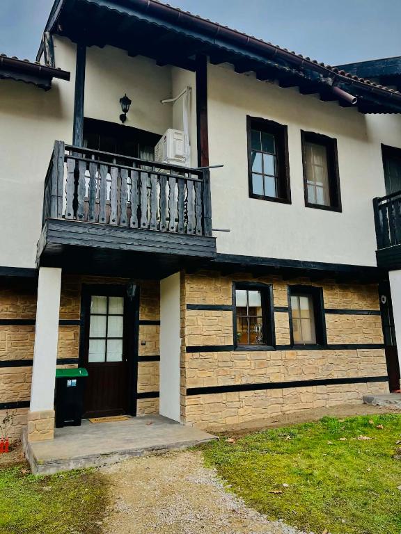 a house with a balcony on the side of it at Къща за гости Геша Форест 3 in Dryanovo