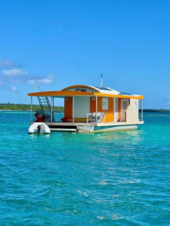 a boat in the water with a house on it at Lagoon Lodge Caraïbes -Lodge flottant sur lagon avec vue mer in Saint-François