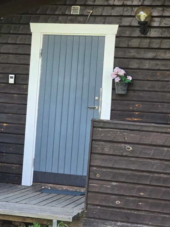 a blue door on a house with a potted flower at Edsken Camping in Hofors