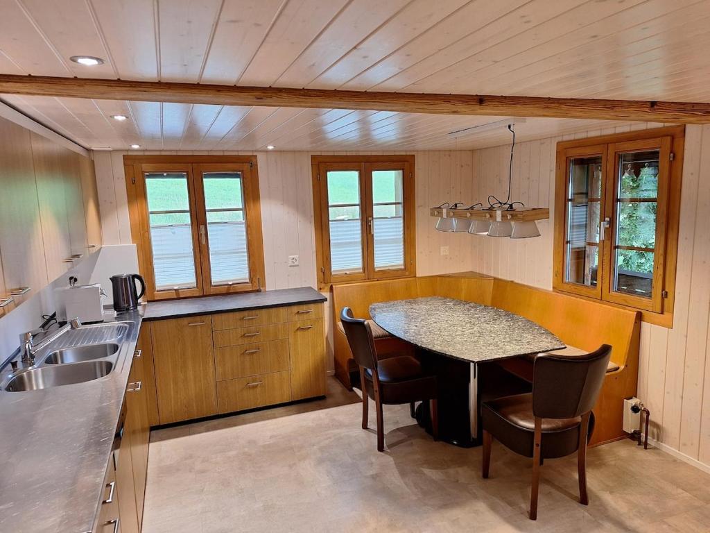 a kitchen with a table and chairs and a sink at Rustikale Wohnung auf dem Bauernhof in Malters