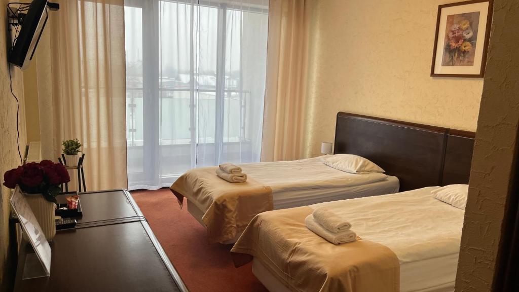 a hotel room with two beds and a window at Neptun in Legnica