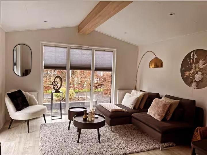 a living room with a couch and a table at Chalet de Hofstee 118 in Nunspeet