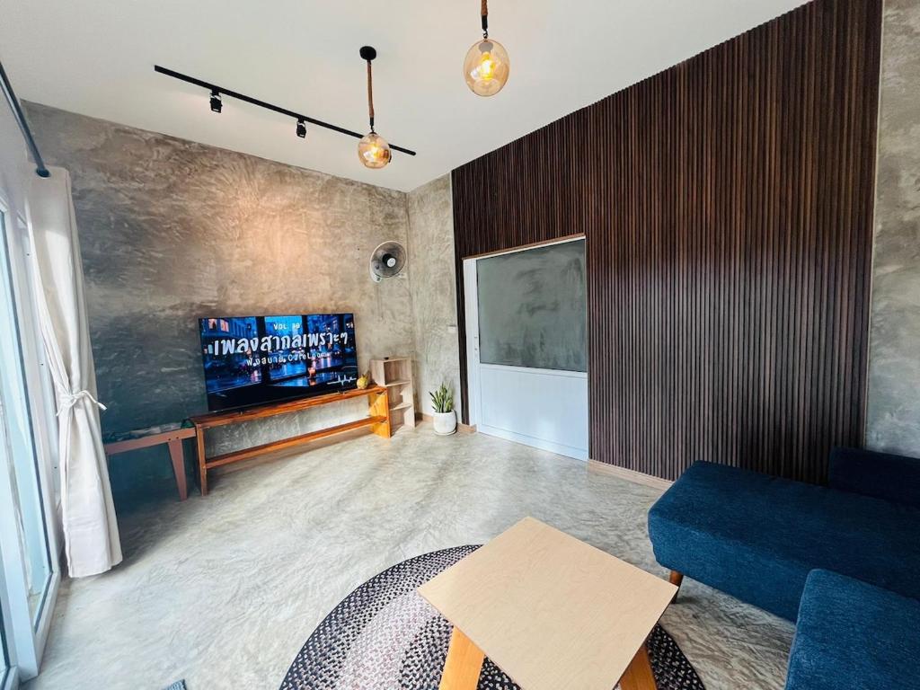 a living room with a blue couch and a tv at Modern Elephant Lagoon Villa in Ko Chang