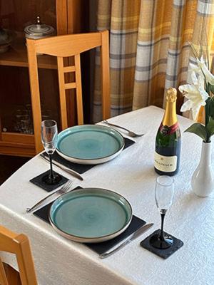 ein Tisch mit zwei Tellern und einer Flasche Wein in der Unterkunft Westview Accommodation in Stornoway