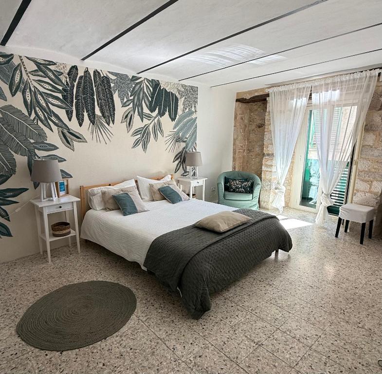 a bedroom with a large bed with a large leaves wallpaper at Il Tempio Del Gufo in Casoli