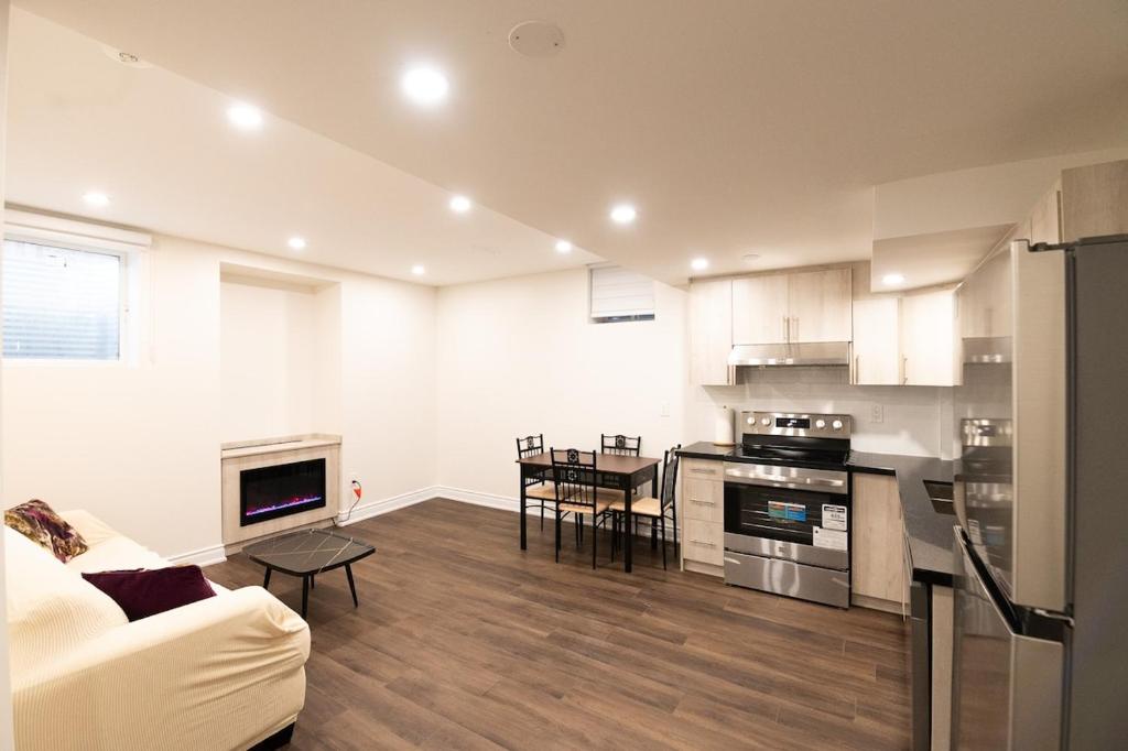 a kitchen and living room with a couch and a table at New Basement Apartment with parking in Oakville