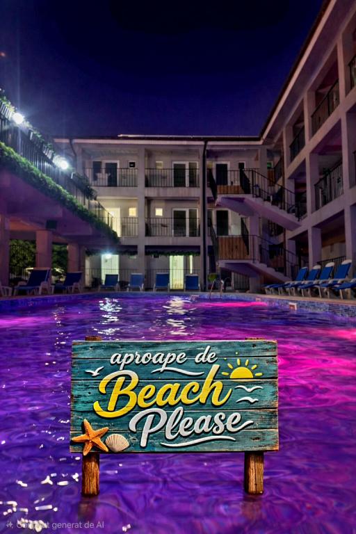 a sign in the middle of a beach place at night at VILA APROAPE DE MARE/ LA CASTEL in Costinesti