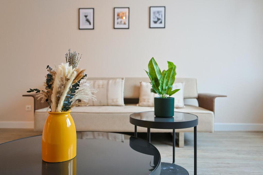 a living room with a yellow vase and a table at KasselRooms Comfort Studio in Kassel