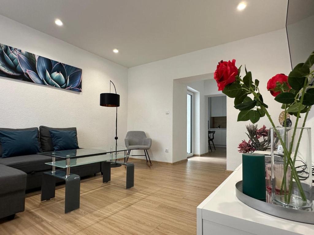 a living room with a couch and a table with red flowers at Apartmán centrum Spišská Nová Ves in Spišská Nová Ves