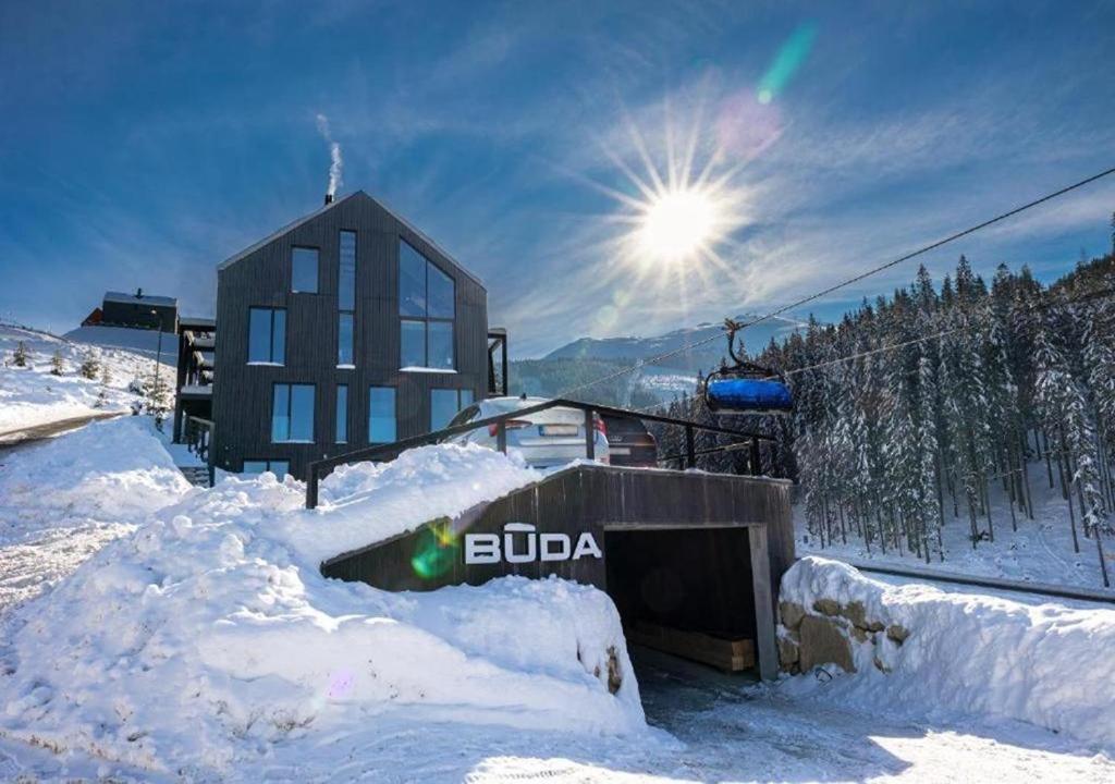 a snow covered ski slope with a building in the background at JASNÁ Luxury Apartments with Mountain View in Belá