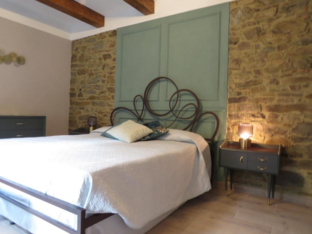 a bedroom with a bed and a stone wall at Casale Santa Margherita in Bucine