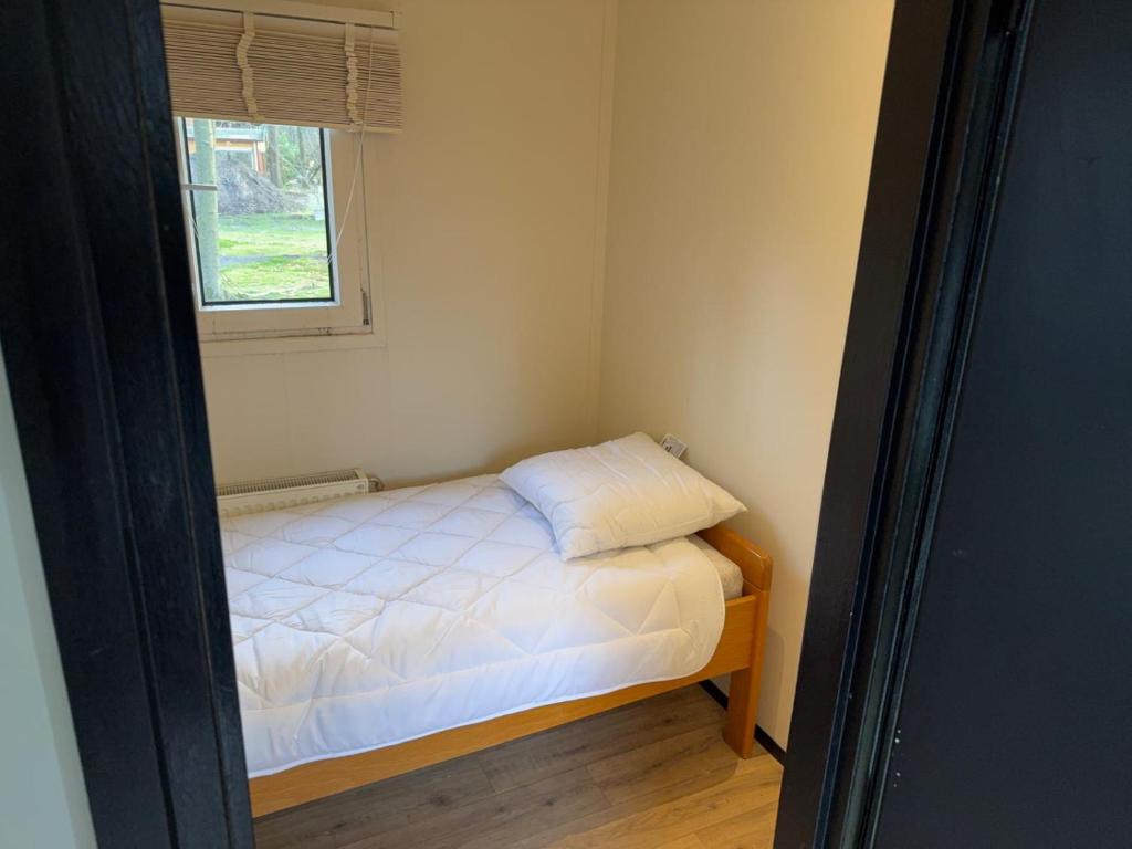 a small bedroom with a bed and a window at First houses 82 in Rijen
