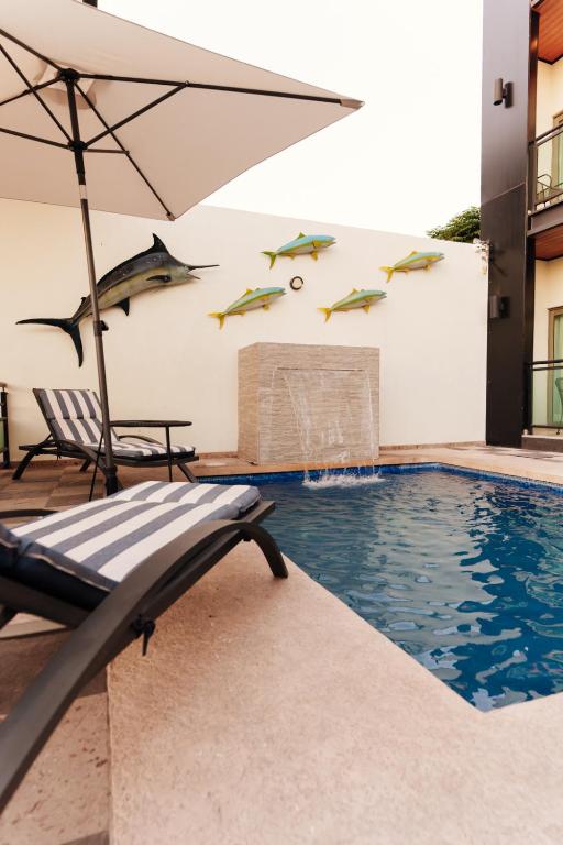a swimming pool with an umbrella and a chair next to a building at Costa Apartments in La Paz
