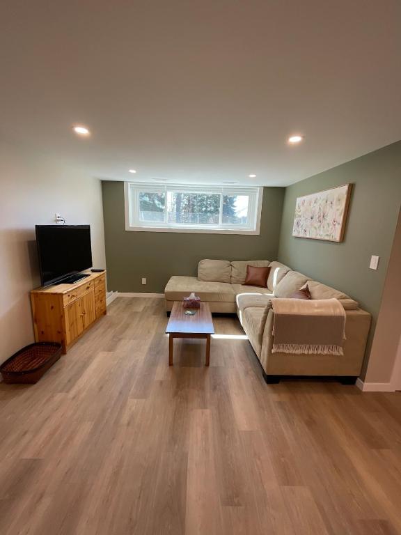 a living room with a couch and a tv at The Basement Suite on Paradise Hill in Prince George